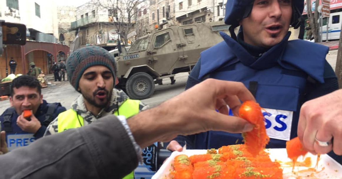 صحفي يوزع الحلوى بعد إنجابه طفل خلال مواجهات بالخليل