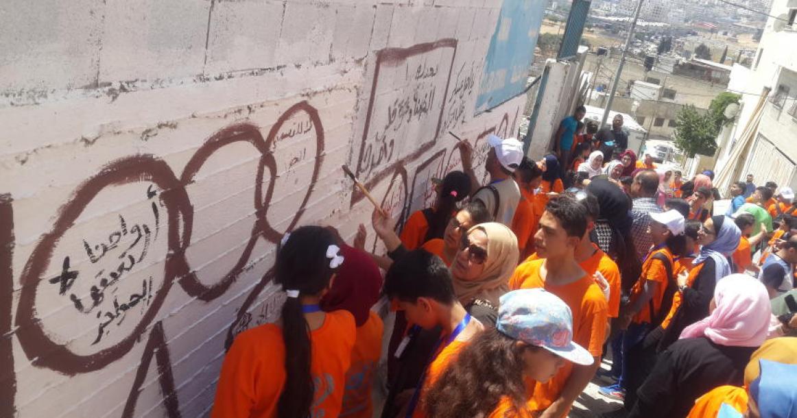 أطفال من غزة يكتبون رسائل على جدران نابلس