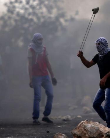 شبان يلقون الحجارة صوب مركبات الاحتلال