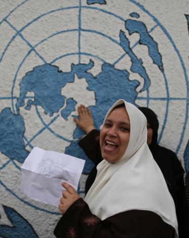 A-Palestinian-woman-holds-her-refugee-ration-card-during-a-protest-demanding-the-United-Nations-Relief-and-