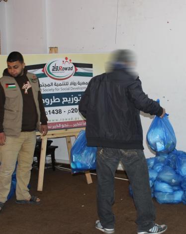 "روّاد" توزيع عشرات الطرود الغذائية للأسر المتعففة بغزة