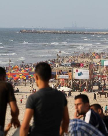 مواطنون يصطفون على شاطئ بحر مدينة غزة