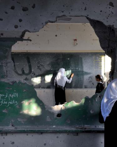 palestine-gaza-school-classroom-shelled-hole-in-the-wall-board