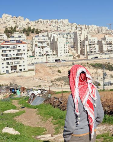 -فلسطيني-أمام-مستوطنة-اسرائيلية-تم-بنائها