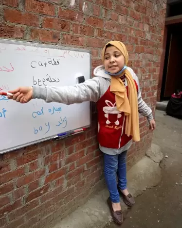 تلميذة صغيرة تصبح معلمة كبيرة في أحد أحياء مصر