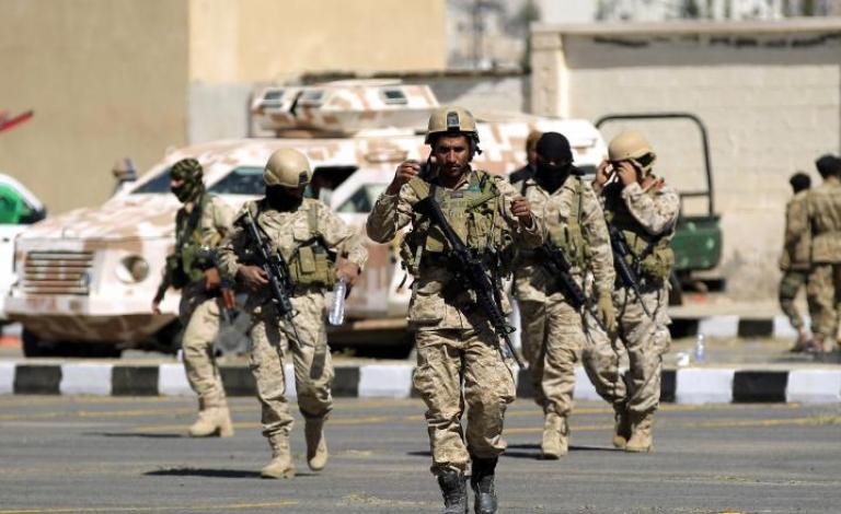 Shiite Huthi fighters walk outside in front of al-Saleh mosque