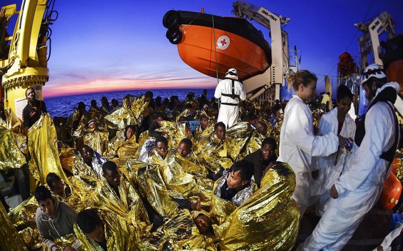 3B569DF400000578-4029044-Migrants_and_refugees_wrapped_in_survival_foil_blankets_rest_nex-a-18_1481662625873_473212