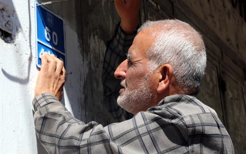 تركيب لوحات الترقيم على واجهات المباني بخانيونس