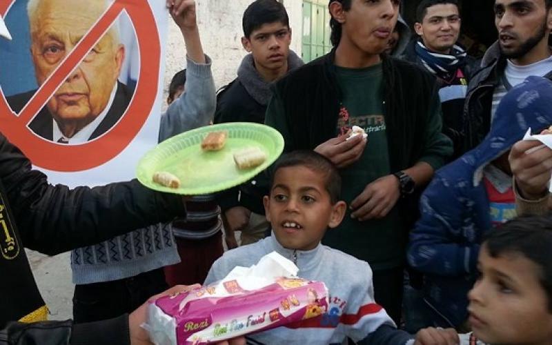 بالصور: توزيع "الحلوى" بغزة لموت شارون