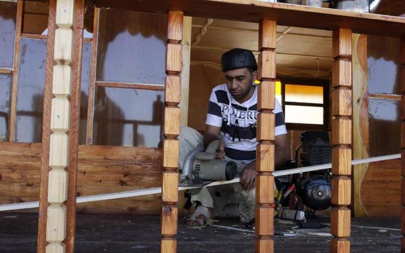 صور: فلسطيني يبني منزلاً من الخشب