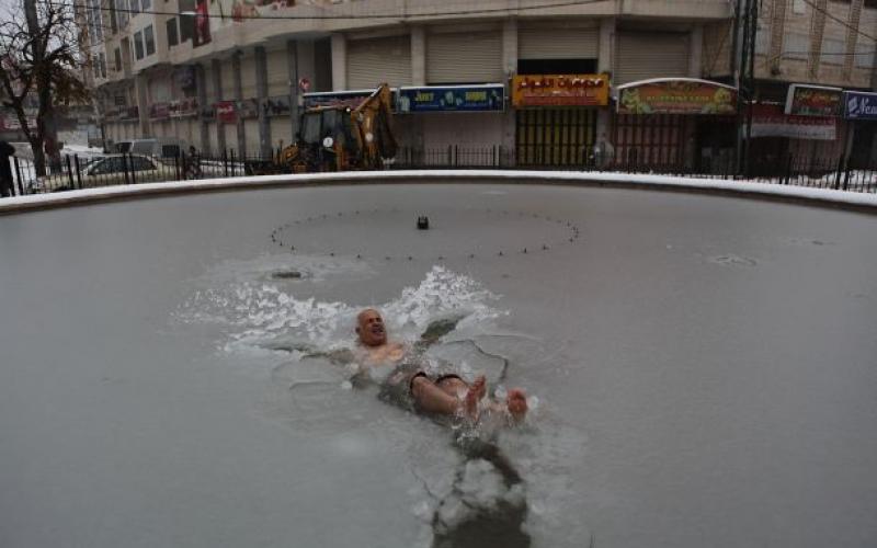 صور: فلسطيني يسبح بالثلج تضامنا مع غزة وسوريا
