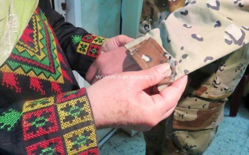 صور‬: أم تجهز العتاد والملابس العسكرية لابنها