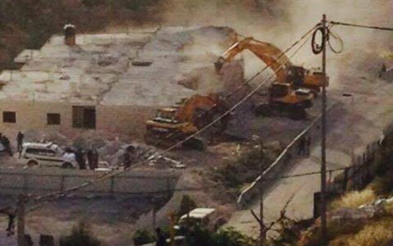 بالصور: الاحتلال يهدم مبنى ومحال تجارية بالقدس