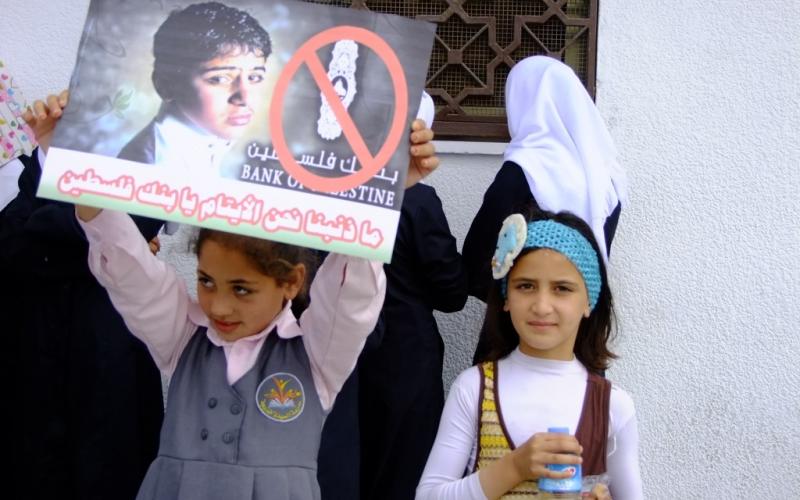 بالصور: الأيتام يحتجون أمام بنك فلسطين بالوسطى