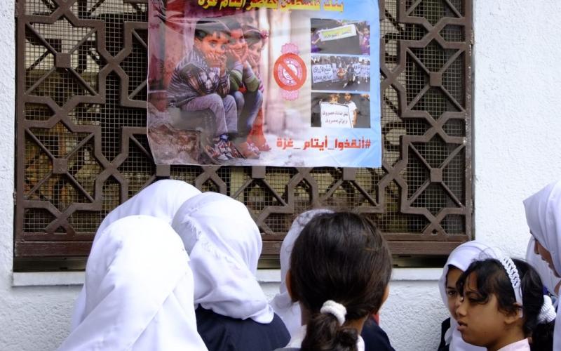بالصور: الأيتام يحتجون أمام بنك فلسطين بالوسطى