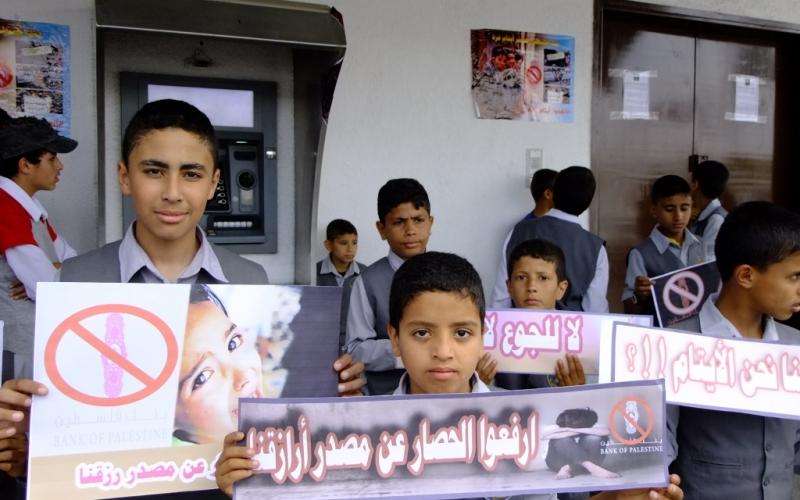 بالصور: الأيتام يحتجون أمام بنك فلسطين بالوسطى