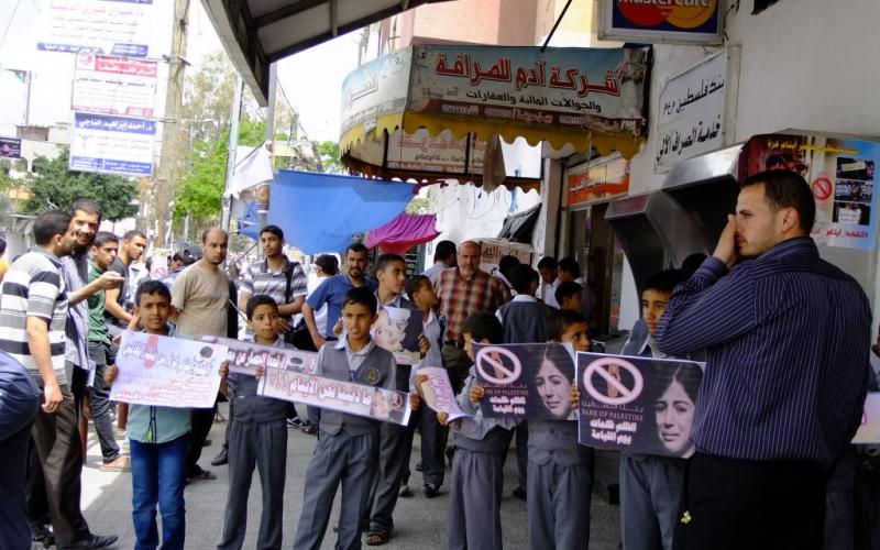 بالصور: الأيتام يحتجون أمام بنك فلسطين بالوسطى