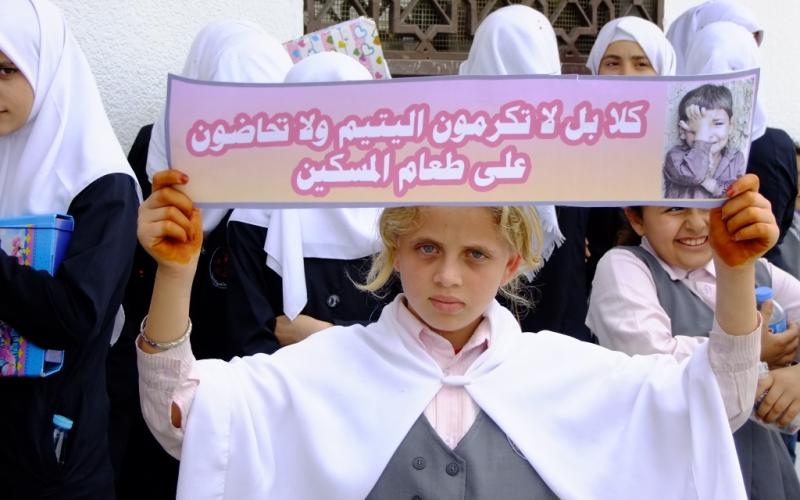 بالصور: الأيتام يحتجون أمام بنك فلسطين بالوسطى