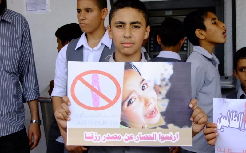 بالصور: الأيتام يحتجون أمام بنك فلسطين بالوسطى