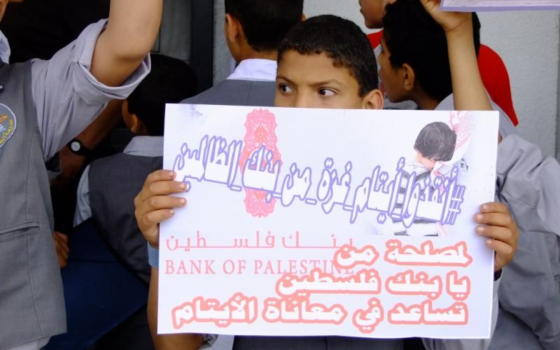 بالصور: الأيتام يحتجون أمام بنك فلسطين بالوسطى
