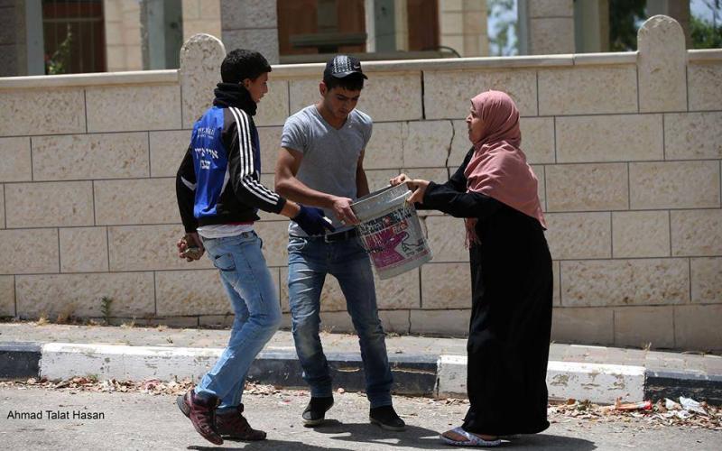 صور: مسنة تنقل الحجارة لشبان خلال المواجهات