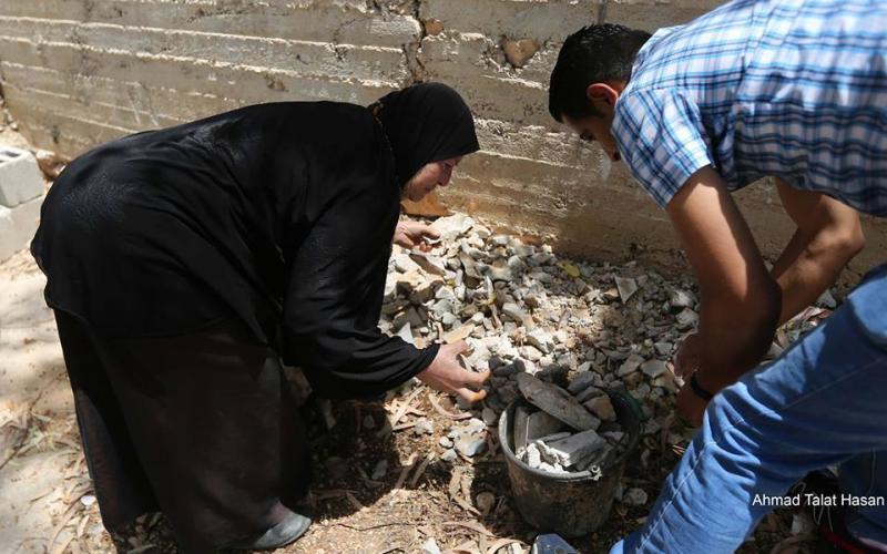 صور: مسنة تنقل الحجارة لشبان خلال المواجهات