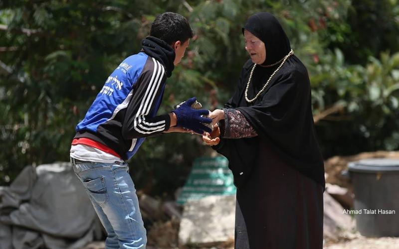 صور: مسنة تنقل الحجارة لشبان خلال المواجهات