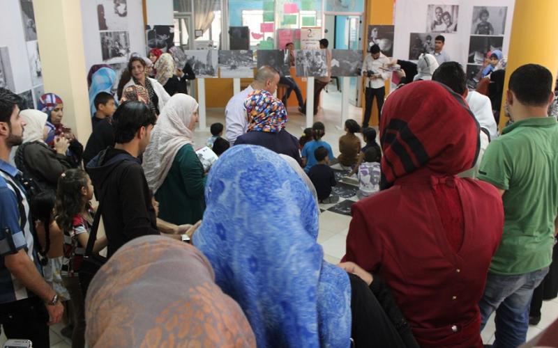 فتيات يستعرضن صور تهميش الأطفال بغزة