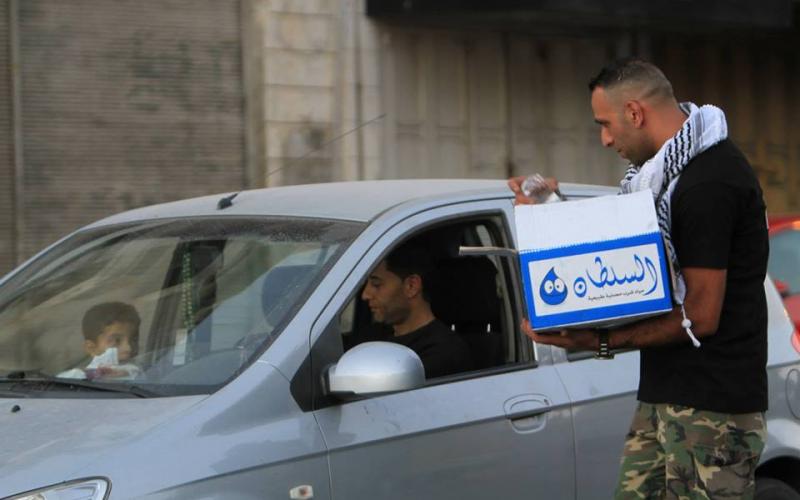 بالصور: مسيحي يوزع التمر على الصائمين