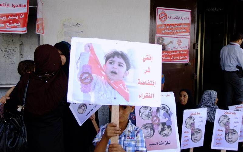 بالصور: أهالي الأيتام يحتجون أمام بنك فلسطين بالوسطى