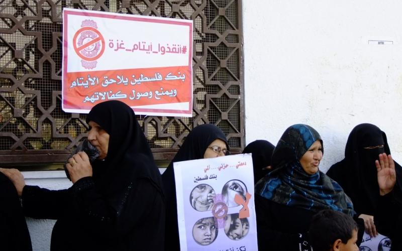 بالصور: أهالي الأيتام يحتجون أمام بنك فلسطين بالوسطى