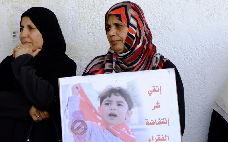 بالصور: أهالي الأيتام يحتجون أمام بنك فلسطين بالوسطى