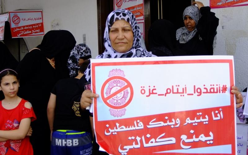 بالصور: أهالي الأيتام يحتجون أمام بنك فلسطين بالوسطى