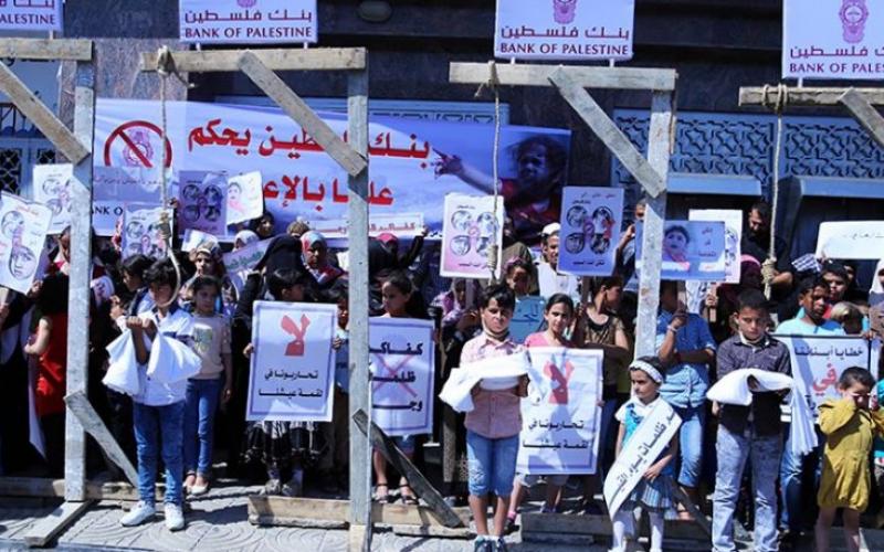 صور: فقراء وأيتام غزة يعلقون المشانق أمام بنك فلسطين