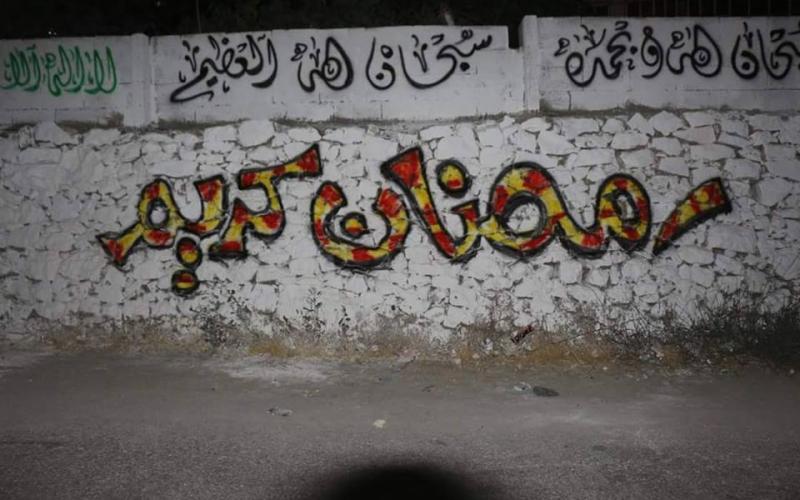 صور: جدران الخليل تتزين بعبارات رمضانية