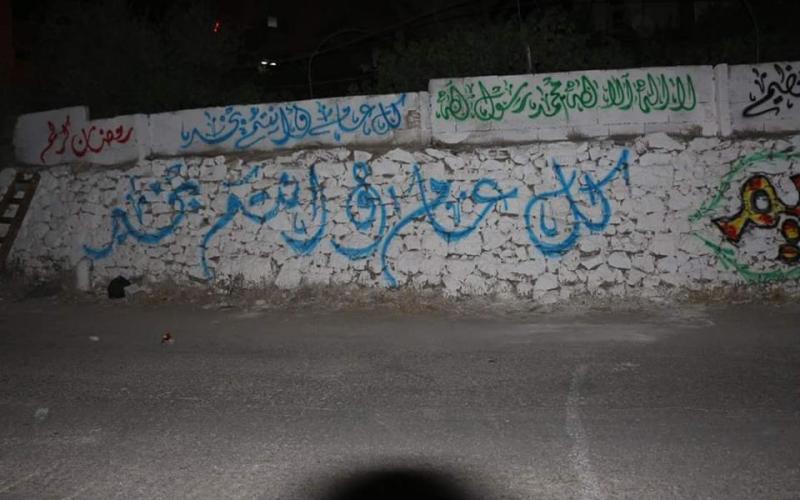 صور: جدران الخليل تتزين بعبارات رمضانية