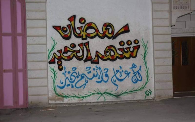 صور: جدران الخليل تتزين بعبارات رمضانية