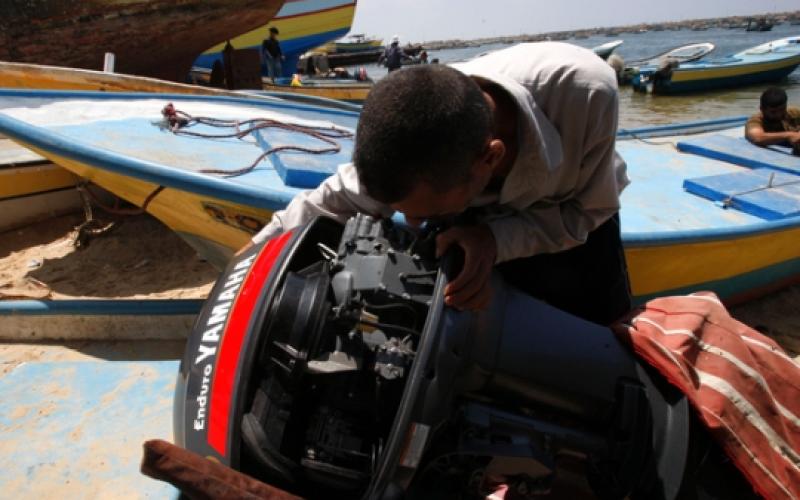 صياد فلسطيني يعد قاربه للصيد-شاطئ غزة