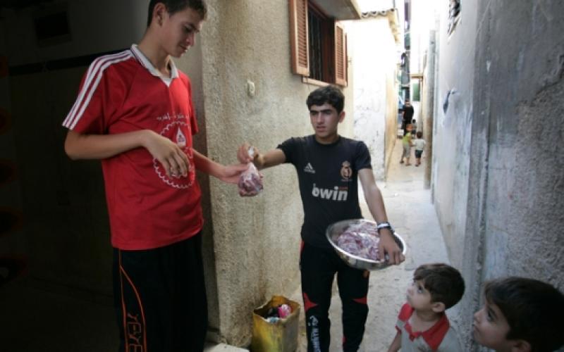 صبي يشارك في توزيع اللحوم على الفقراء