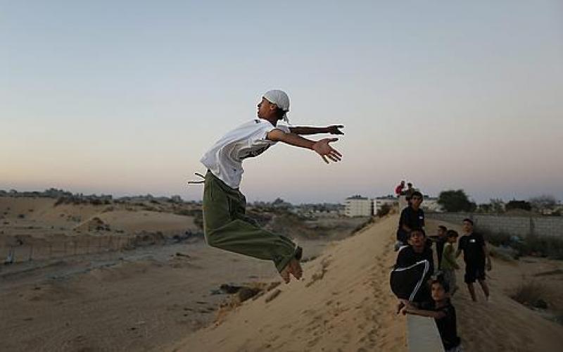 بالصور .. غزيون يمارسون رياضة الباركور
