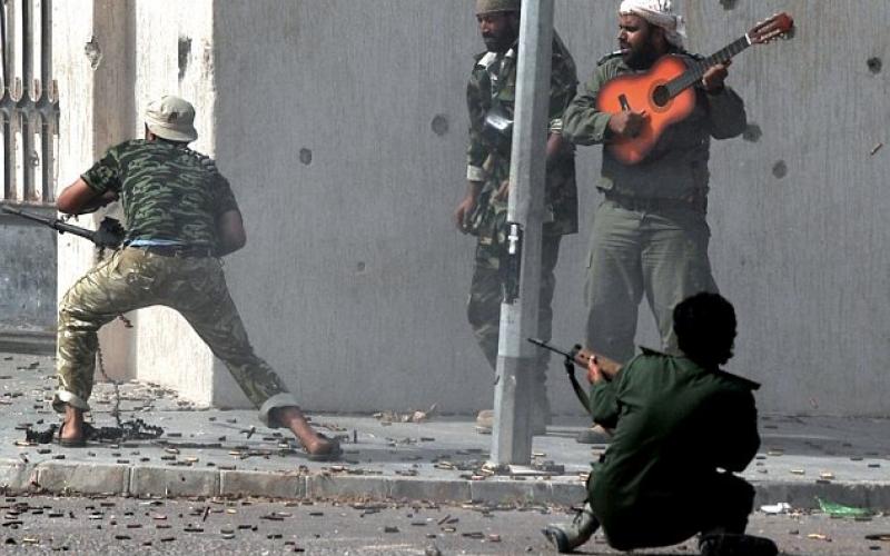 صور..ثائر ليبي يعزف على "الجيتار" بأوج القتال