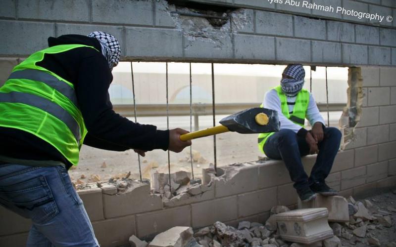 بالصور: ناشطون يهدمون جزءاً من الجدار بالقدس