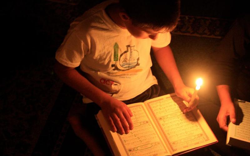 بالصور: طلاب المساجد المدمّرة يحفظون القرآن على الشموع
