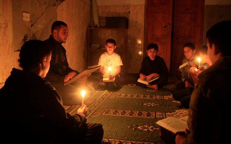 بالصور: طلاب المساجد المدمّرة يحفظون القرآن على الشموع