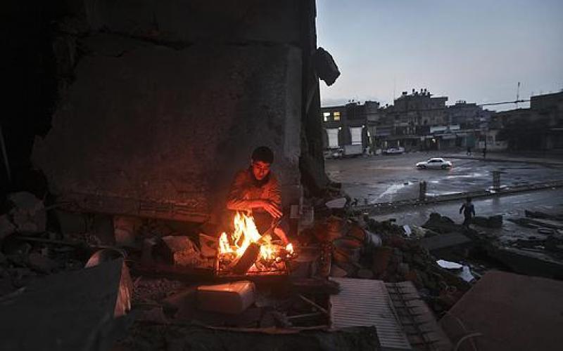 صور.. عائلة فلسطينية تتدفأ قرب منزلها المدمر