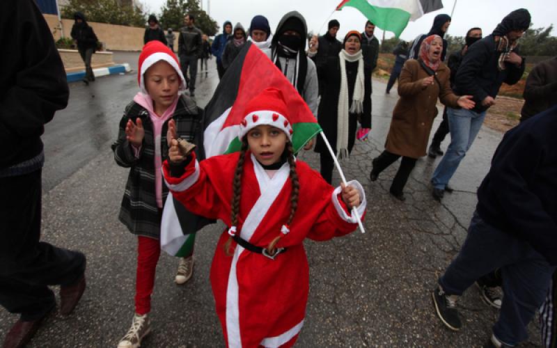 صور.. طفلة "بابا نويل" تشارك بمواجهات الضفة
