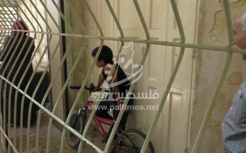 بالصور: جندي يعتدي على طفل ويصادر دراجته في الخليل