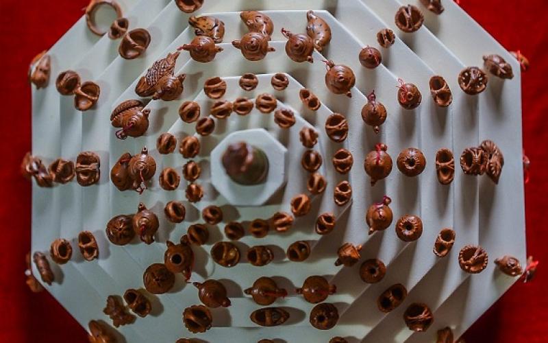بالصور: فنان صيني متخصص بالنحت على بذور الخوخ