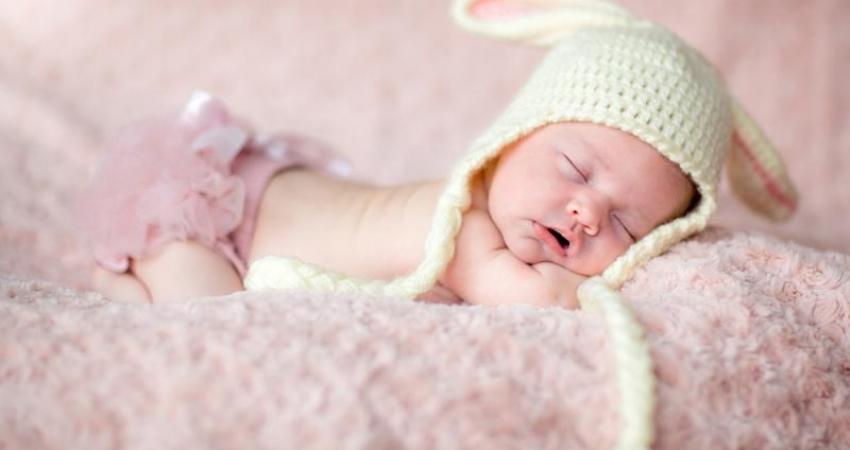 lovely-moment-newborn-baby-wearing-rabbit-ear-cap-lying-on-pink-carpet-photography