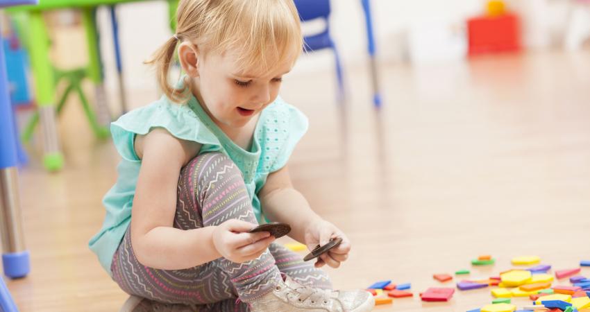 cute-toddler-girl-playing-with-toys-on-daycare-floor-598560038-5be4953746e0fb0026d554b6